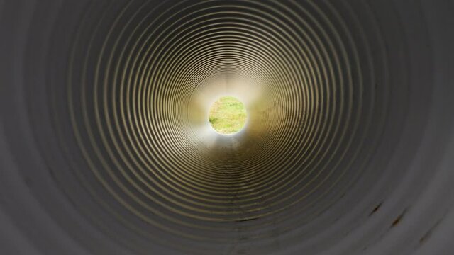 View from inside of plastic water pipe. Light in the end of tunnel