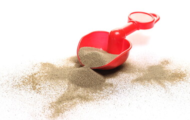 Sand pile with plastic beach toy shovel isolated on white background