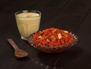 Fototapeta na wymiar Indian Special Famous Winter Sweet Food Carrot Halwa or Gajar ka Halwa Served With Kesar Masala Milk 