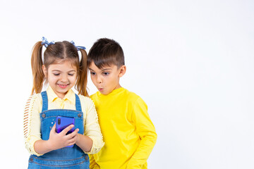 Preschool children are watching something on a smartphone. A boy with a surprised face. White background and side space.