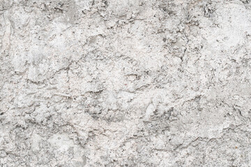 Textured uneven grey plastered or cement wall for background with lots of structural details. Gray shades monochrome