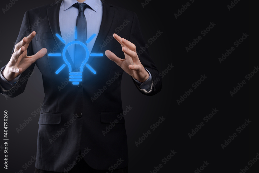 Wall mural businessman in a suit with a light bulb in his hands. holds a glowing idea icon in his hand. with a 