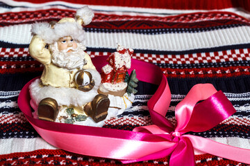 Figurine of Santa Claus on a multicolored knitted background. New Year. Holiday. Background.