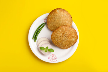 Kachori, green chilly and onion slice in plate. kachori is a spicy snack from India also spelled as kachauri and kachodi.