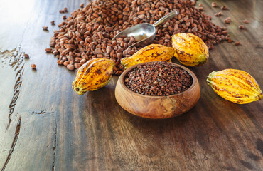 cocoa nibs and cocoa fruit on wooden table