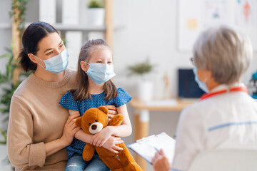 Doctor, child and mother wearing facemasks