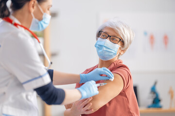 Fototapeta premium Doctor giving a senior woman a vaccination