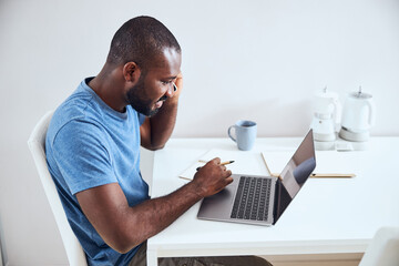 Man comparing his notes with a phone information