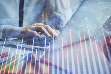 Fototapeta premium Double exposure of woman hands typing on computer and financial graph hologram drawing. Stock market analysis concept.