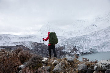 Fototapeta premium Strong woman backpacker hiking in winter mountains