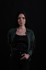 Portrait of beautiful young brunette woman on black background