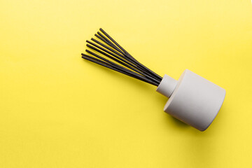 Overhead view to aroma reed diffuser on yellow background, trend and mod colors of 2021 year...