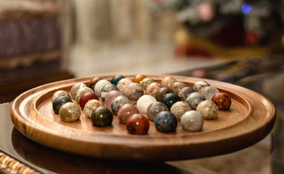 Marble Solitaire Board Game On Table. Wooden Board With Marbles For Playing Peg Solitaire.