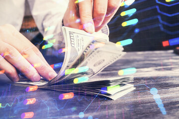 Double exposure of technology drawing hologram and us dollars bills and man hands. Data concept
