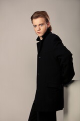 Obraz na płótnie Canvas Young guy posing in a black coat