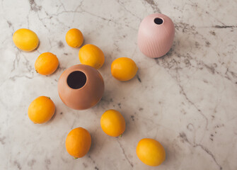 Lemons and vases on a white marble table. Minimal food arrangement.