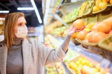 Woman in medical masks is shopping in grocery store during virus pandemic