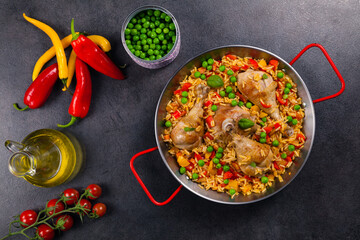 Arroz con pollo. Baked pieces of chicken with bone, rice with paprika and peas.