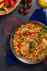Arroz con pollo. Baked pieces of chicken with bone, rice with paprika and peas.
