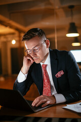 Young businessman using computer in his office. Handsome man working at his workplace..