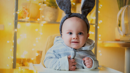 Easter concept. Happy little baby boy with bunny ears smiling at home.