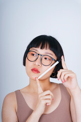 Young asian woman short bob hairstyle wearing sunglasses holding pen isolate on white background.