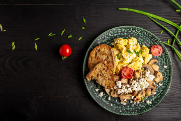 Nutritious scrambled eggs with mushrooms, onion and tomatoes for breakfast. banner, menu recipe place for text, top view