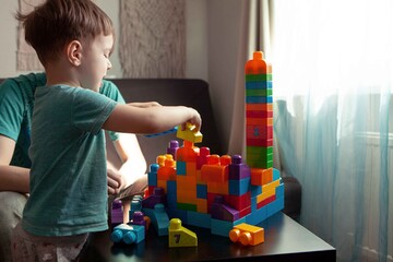 Fototapeta premium Dad and son playing in the constructor. Self-isolation concept for fighting Covid-19