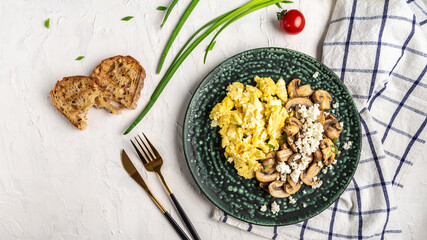 Scrambled Eggs with Mushrooms and Cottage Cheese. Delicious breakfast or snack on a light background, top view