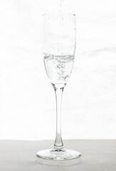 Filling up the champagne glass water  isolated on a white background