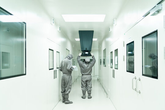 The unidentified operators is using the capture hood balometer to measuring the air velocity and volume of supply air from HVAC system in the clean room and record the measurement value.