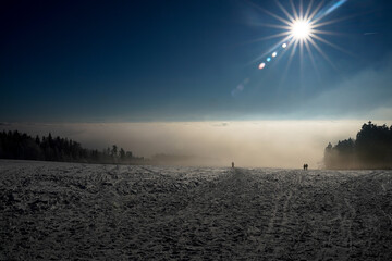 Leute entfliehen im Winter dem Nebel, der Sonne entgegen, Sonnenstern über der Nebeldecke
