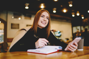 Happy female thinking about project while resting in cafe