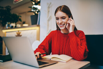 Positive young lady explaining project details during phone conversation