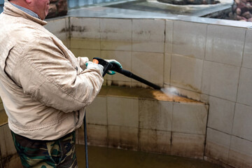 Cleaning swimming pool using high pressure power washer.