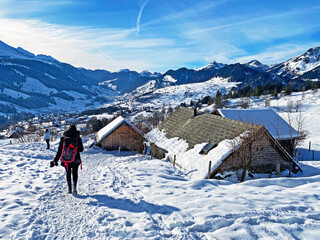 Hikers and walkers on the beautiful idyllic fresh snow of the Alpstein mountain massif and in the...