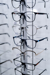 Row of glasses at an opticians. Eyeglasses shop. Stand with glasses in the store of optics. Showcase with spectacles in modern ophthalmic store. Closeup.