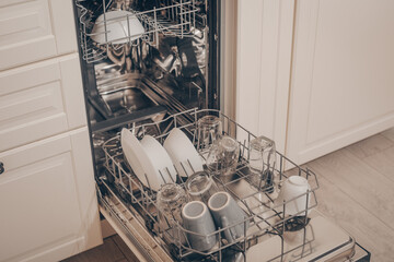 Built-in dishwasher in the kitchen, washing dishes. Plates, cups, glasses are worth washing. Household chores, everyday life