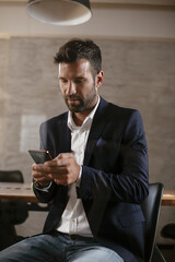 Businessman in conference room using the phone. Handsome businessman making a business plan.
