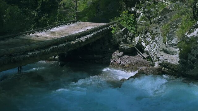 Log trestle bridge (without support, construction of thick long trunks) across mountain rapid river (dalles) for driving cattle (stock driving road on mountain pastures).
