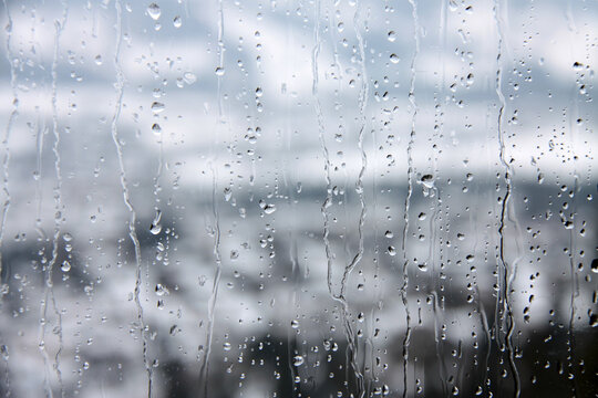 Regenwetter bringt Wassertropfen auf Glasscheibe am Fenster