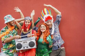 Happy friends celebrating carnival party outdoor - Young crazy people having fun wearing costumes...