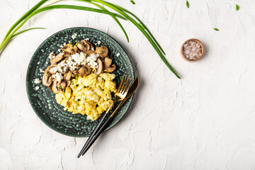 scrambled eggs with champignon mushrooms. Delicious breakfast or snack on a light background, banner, menu, recipe. top view