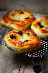 Appetizing mini pizzas on a cooling rack. Homemade mini pizzas. Baking at home.