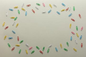Abstract background in trendy gray color of the year, paper clips of different colors on backdrop