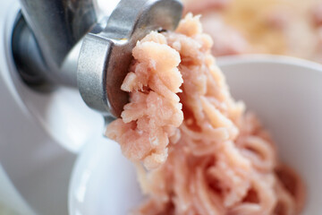 Process of meat grinding in the kitchen with mincing machine.