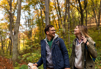 Smiled couple holding hands and enjoying in the forest