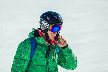 Young athlete freestyle Skier using phone on sunny day during winter season