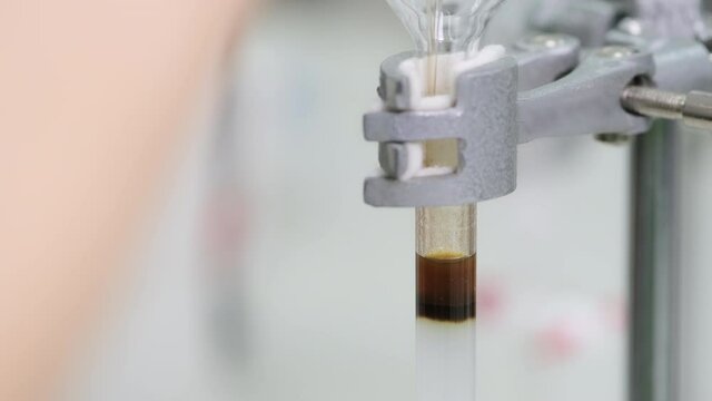 Researcher loading brown sample into glass column and sed solvent to elute the sample out of the column. Silica gel was packed into a column. Column chromatography technique. e-learning concept.
