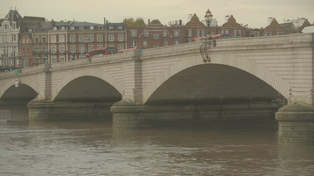 Busses driving over Putney bridge at river Thames, London